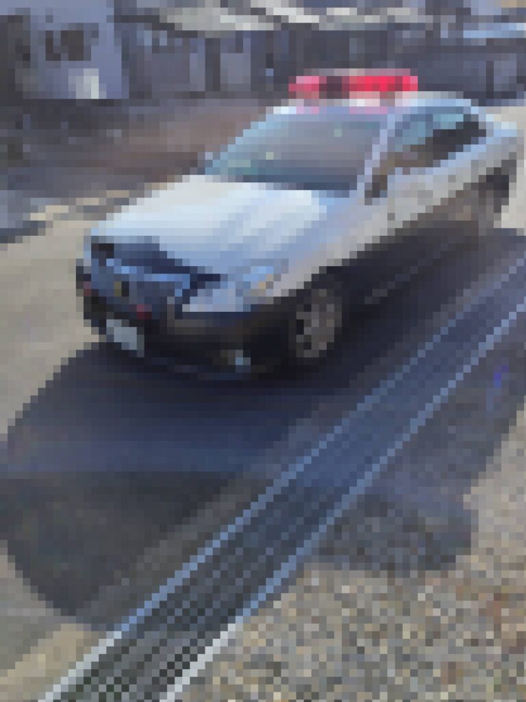 投資詐欺の動産執行当日、詐欺師Kの自宅前に到着した警察車両の様子